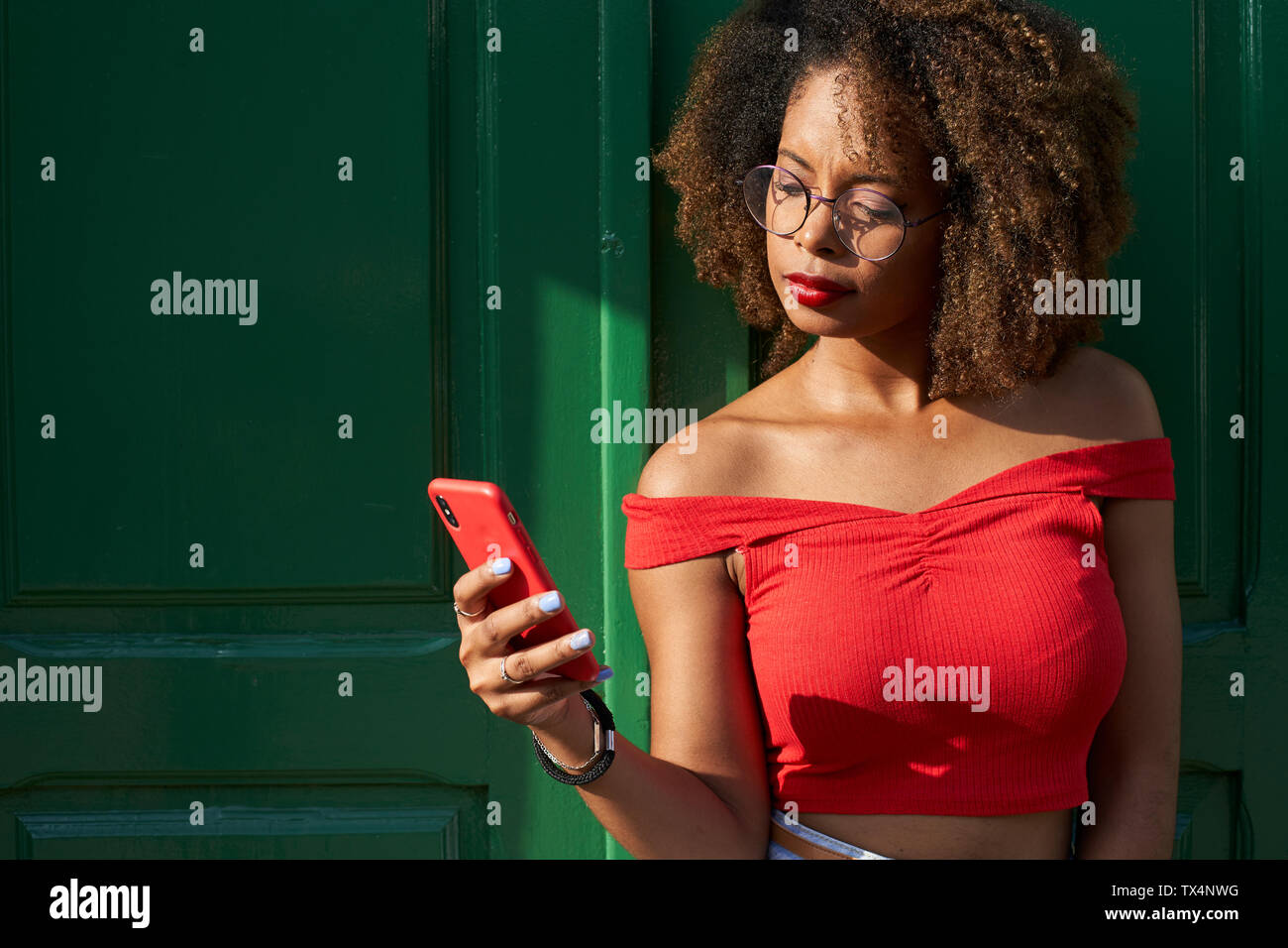 Woman in red checking her phone Stock Photo