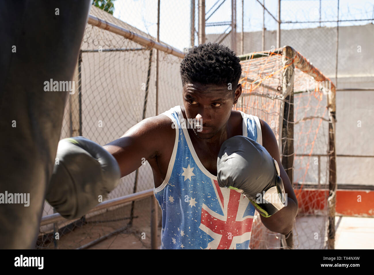 Boxer training with punching bag Stock Photo