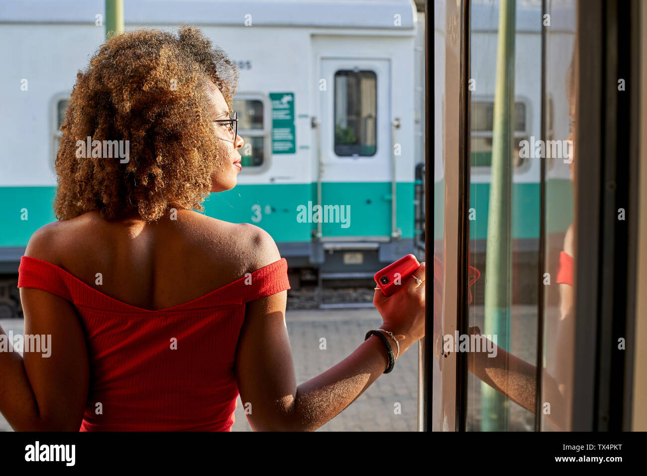 Woman looking out of train door Stock Photo