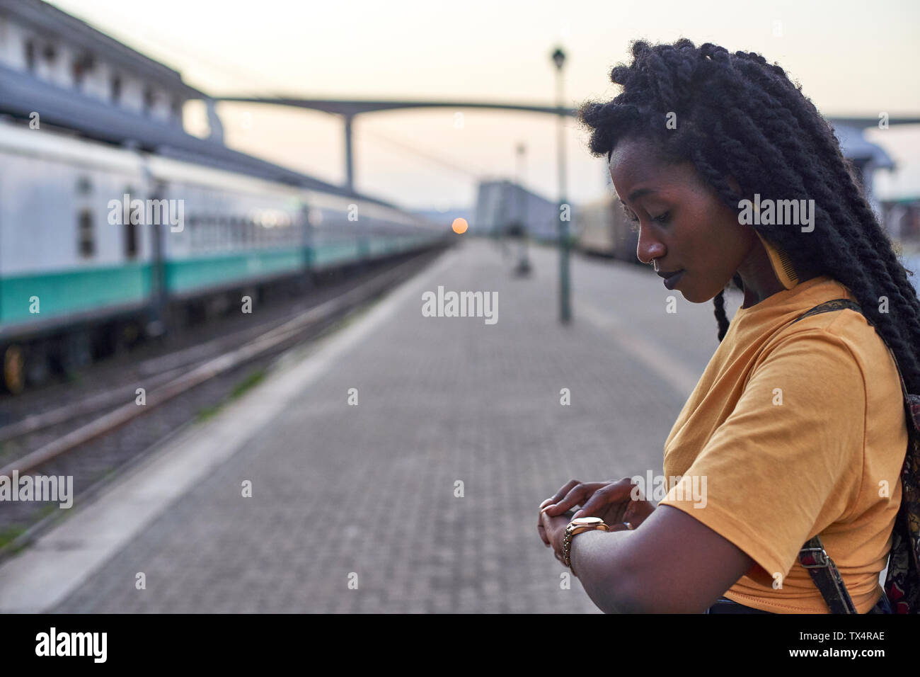 Young woman on platform at the train station checking her watch Stock Photo