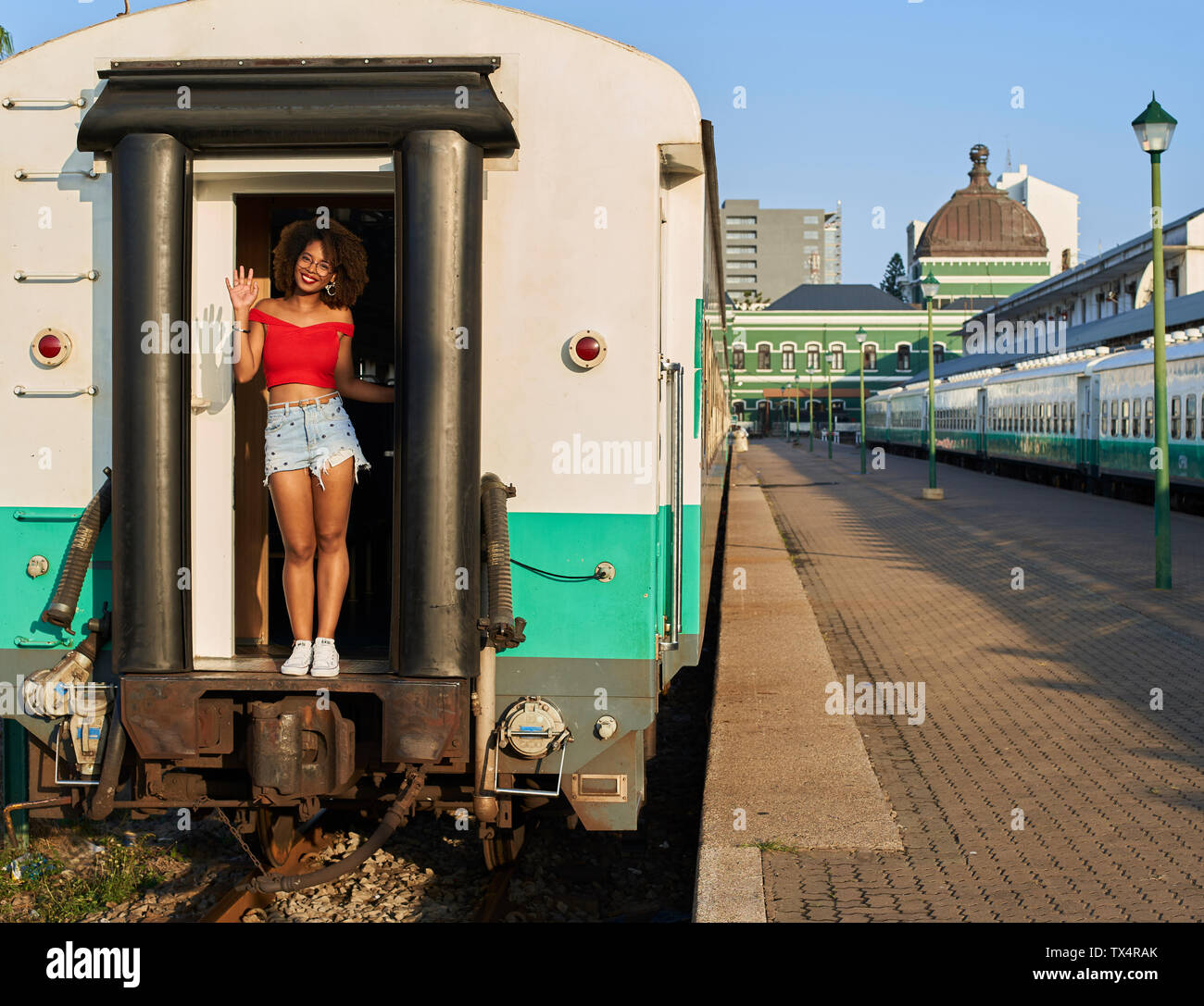 Smiling woman greeting from the train door Stock Photo