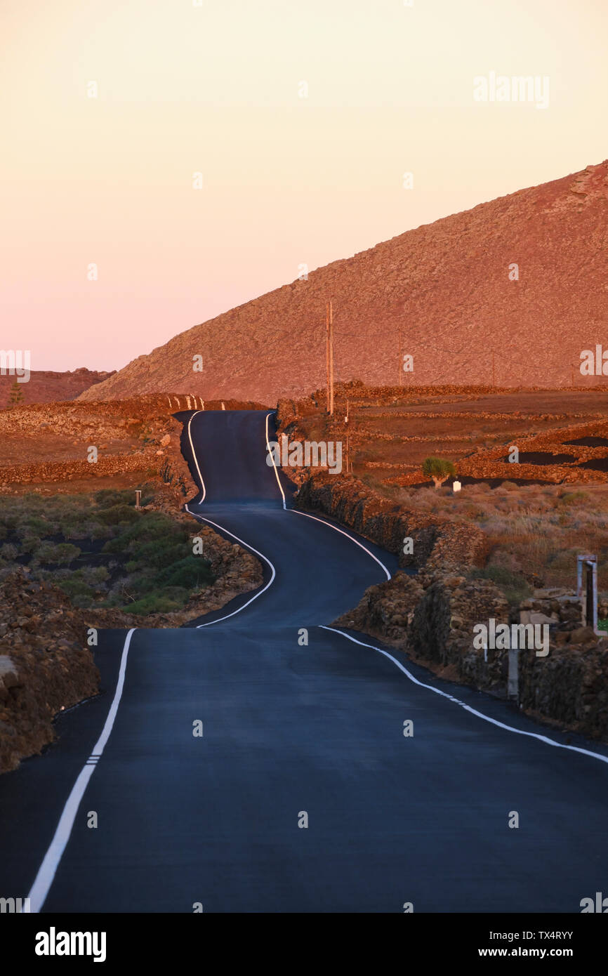 Spain, Canary Islands, Lanzarote, Tinajo, country road at dusk Stock Photo