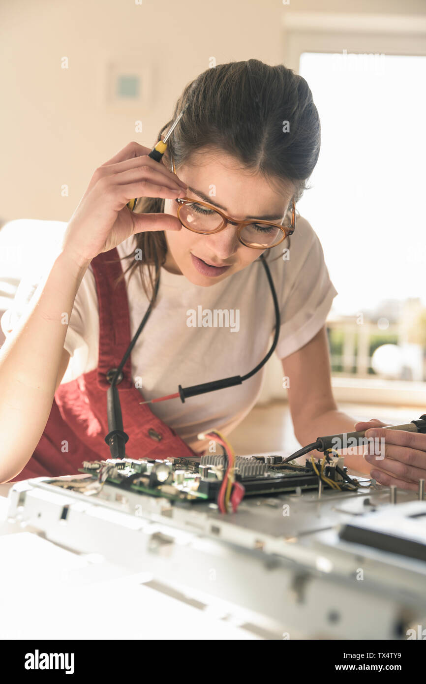 Young woman working on computer equipment at home Stock Photo