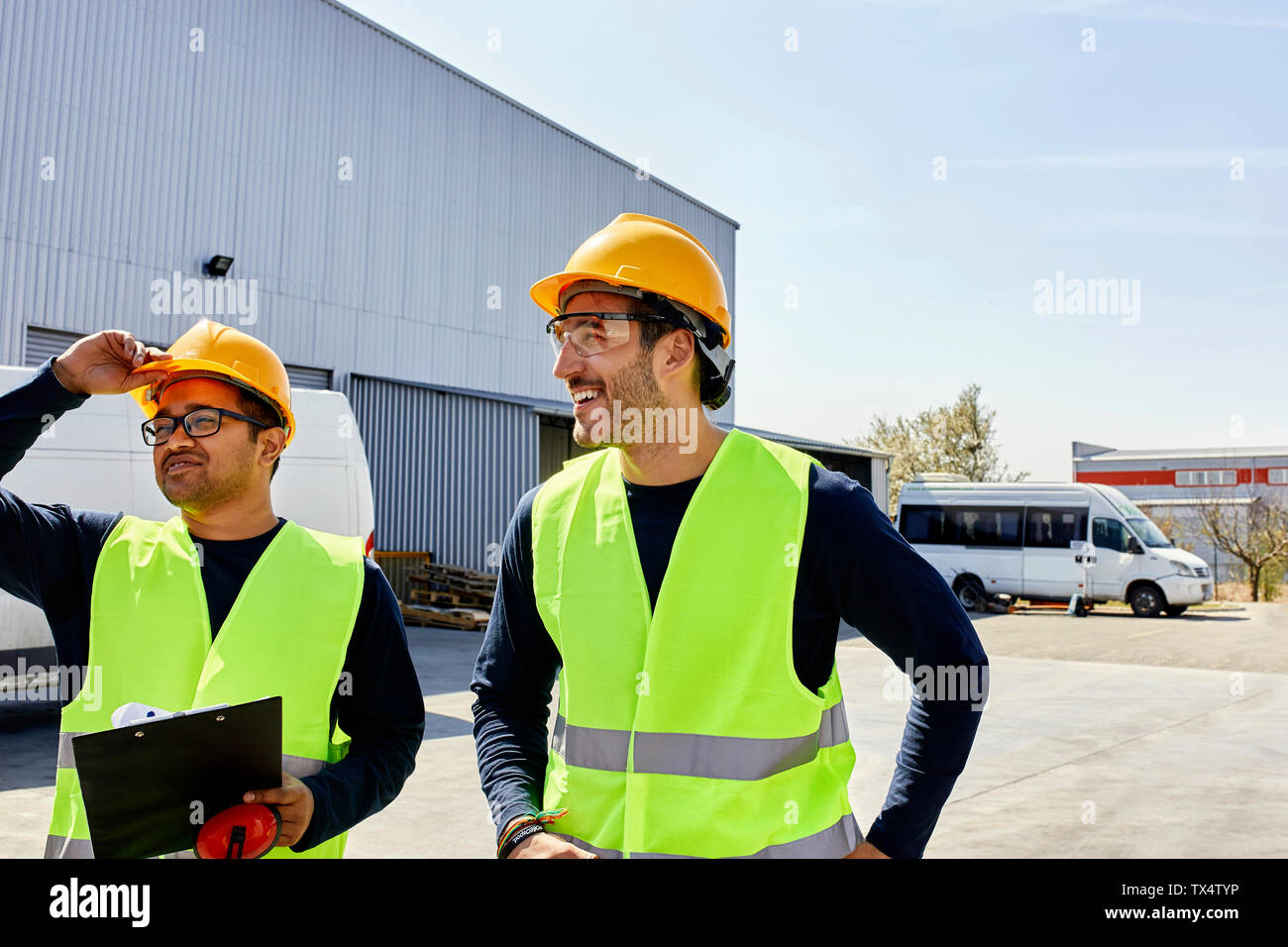 Two workers talking on factory yard Stock Photo