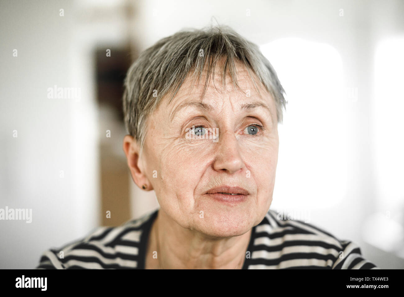Portrait Of Senior Woman With Short Hair Looking Away Stock Photo
