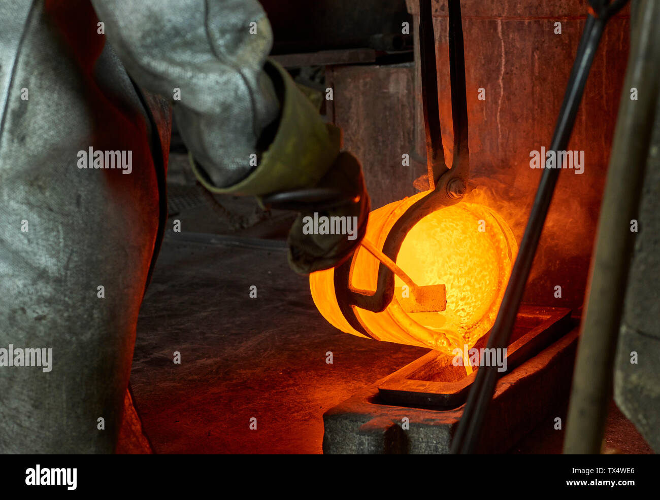 Industry, worker at furnace during melting copper, wearing a fire proximity suit Stock Photo