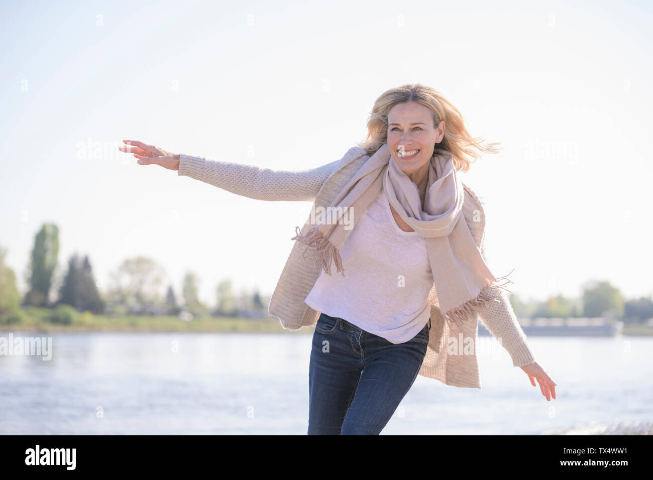 Carefree mature woman at the riverside Stock Photo