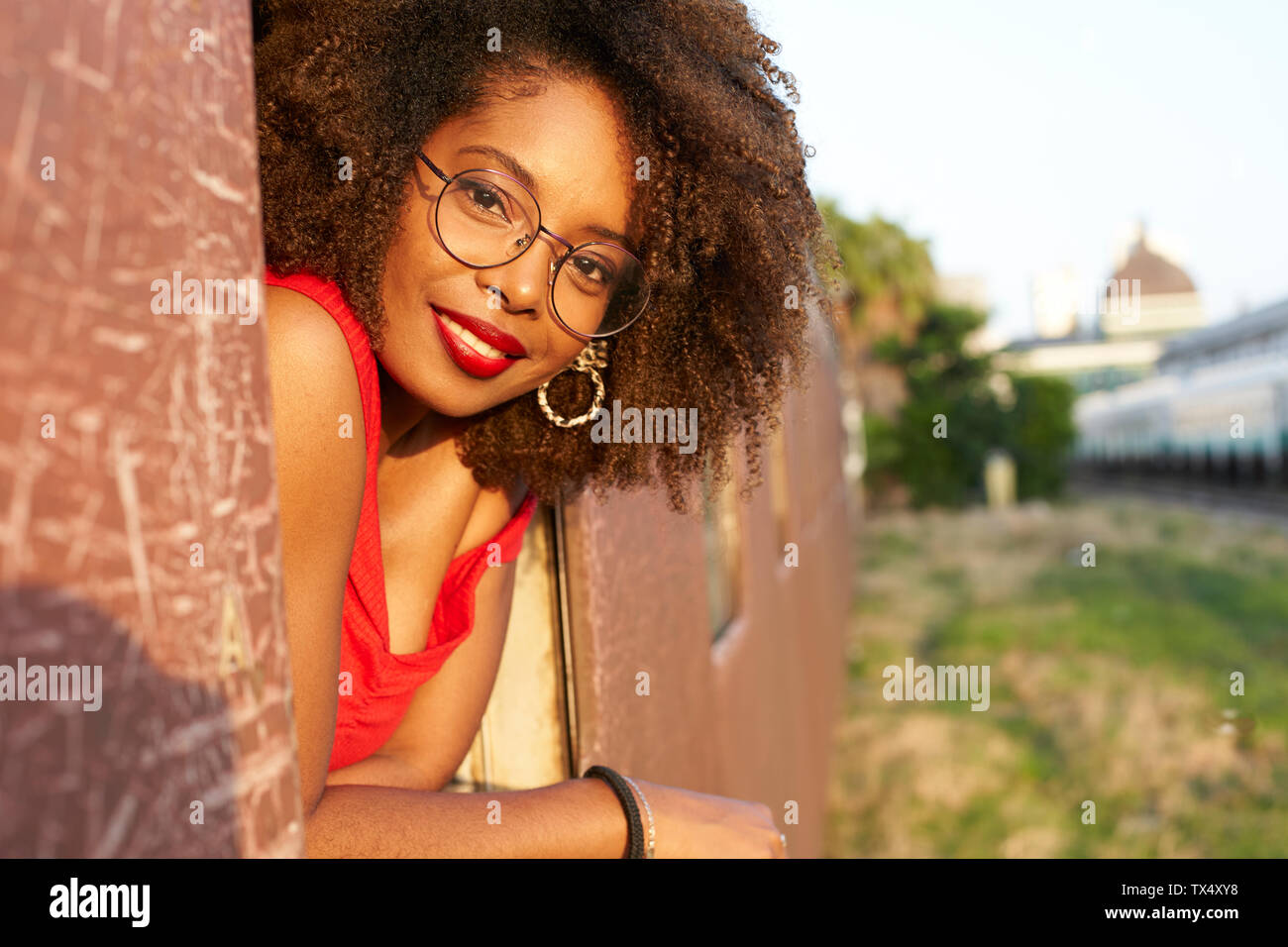 Portrait of smiling woman looking out of train window Stock Photo