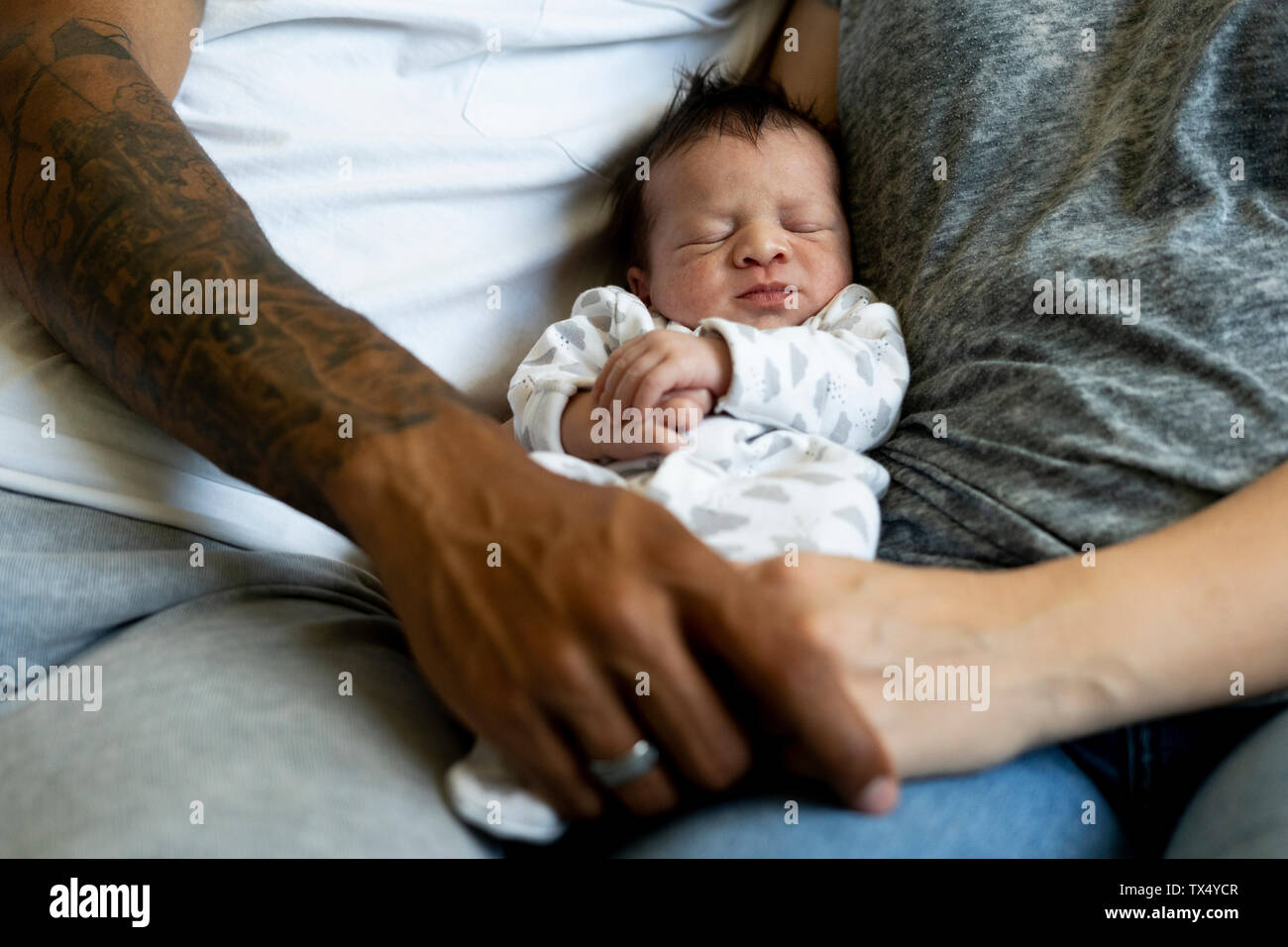Newborn baby between his parents Stock Photo