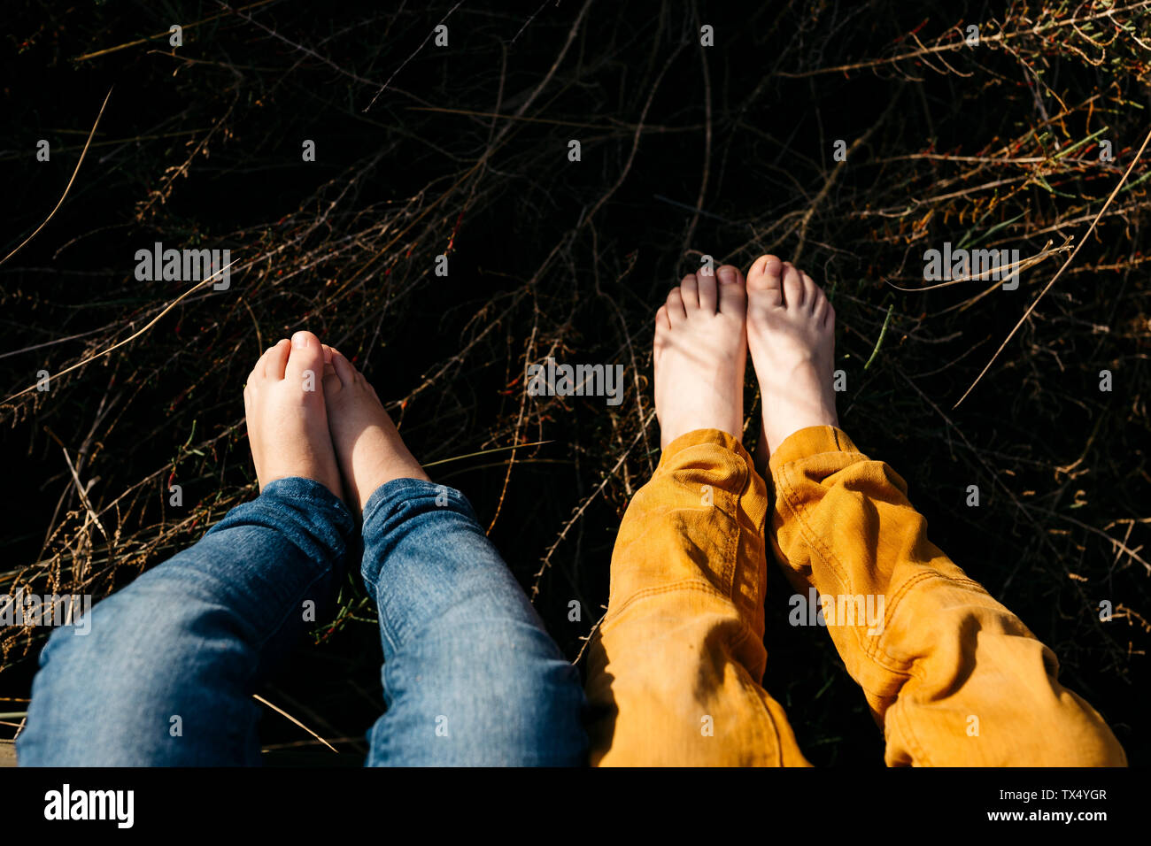 Feet of little girl and her older brother in nature, close-up Stock Photo