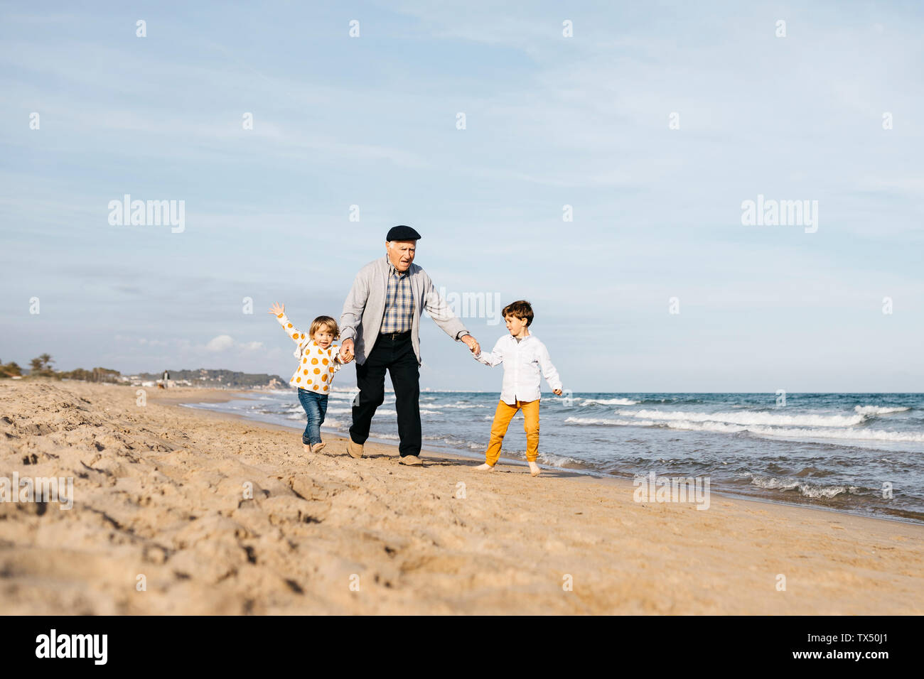 Grandfather having fun with his grandchildren on the beach Stock Photo