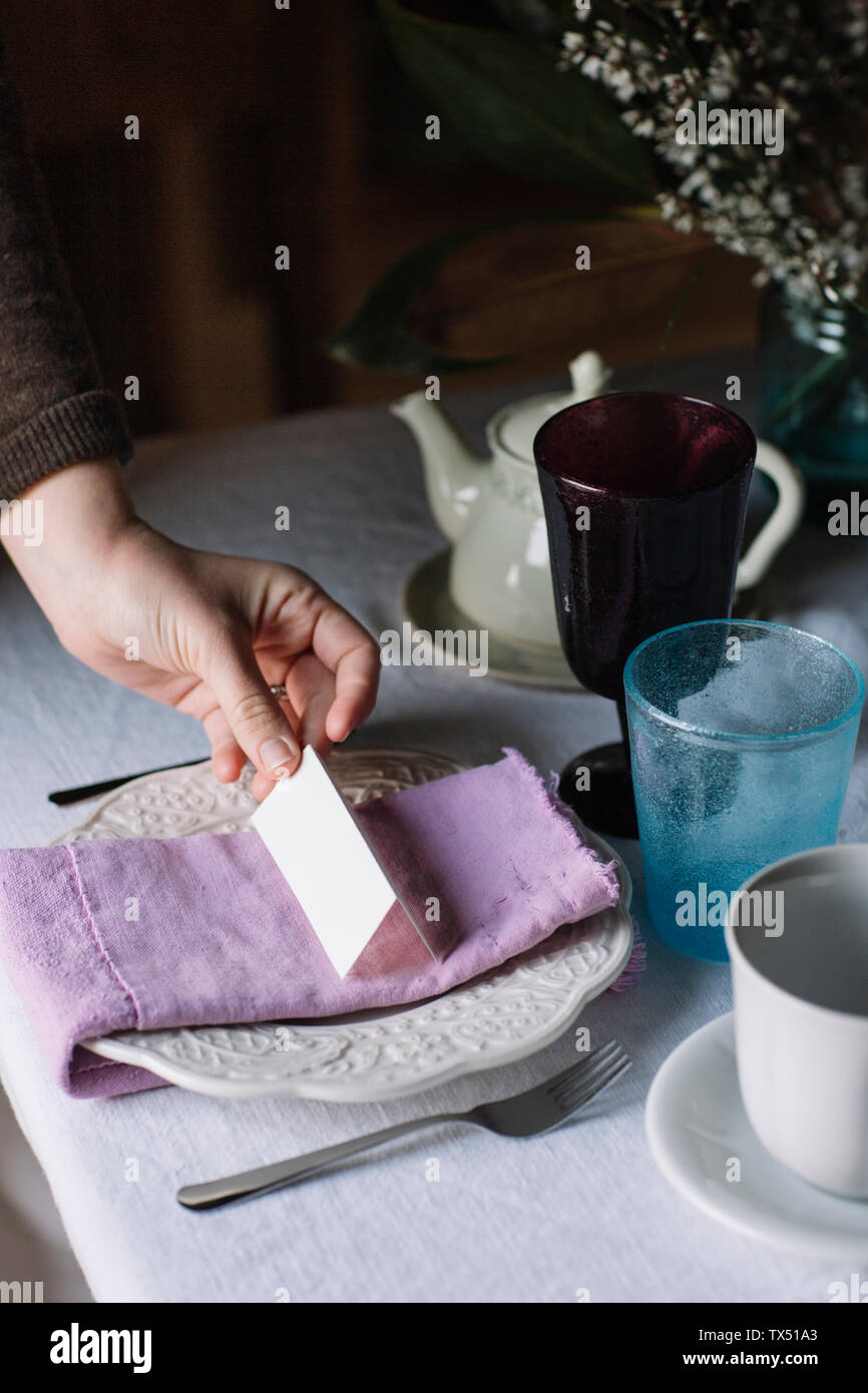 Woman's hand arranging place card at table setting Stock Photo