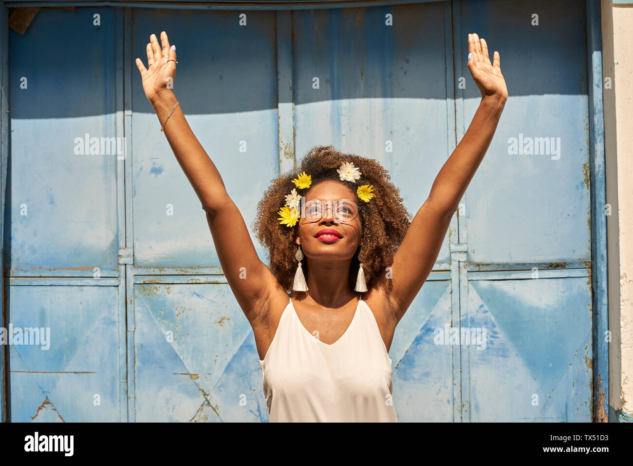 Portrait of happy young woman with red lips wearing glasses and flowers in her hair Stock Photo