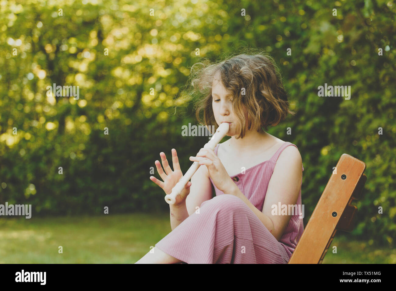 A girl playing the flute in the garden Stock Photo Alamy