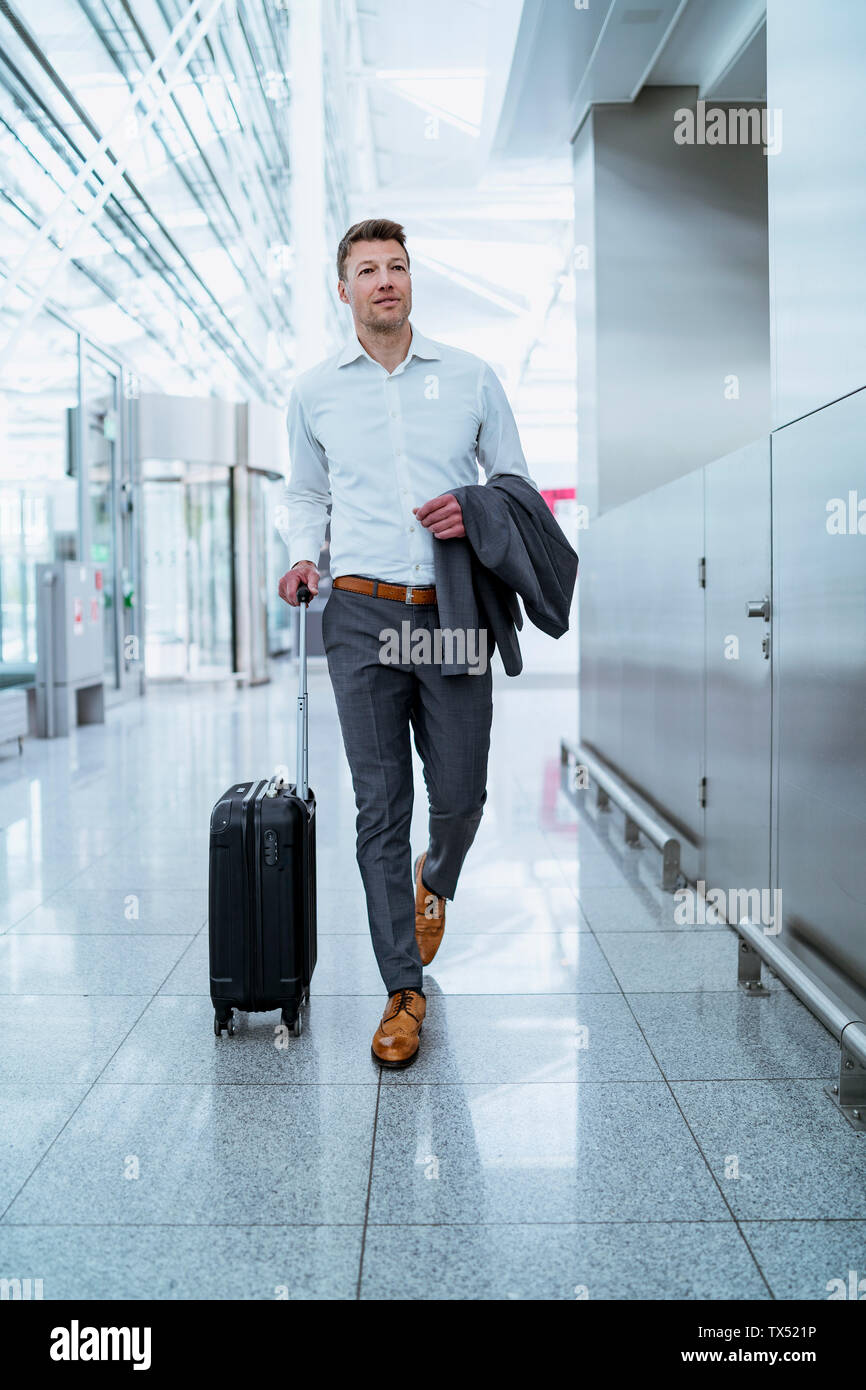 Businessman walking with baggage at the airport Stock Photo