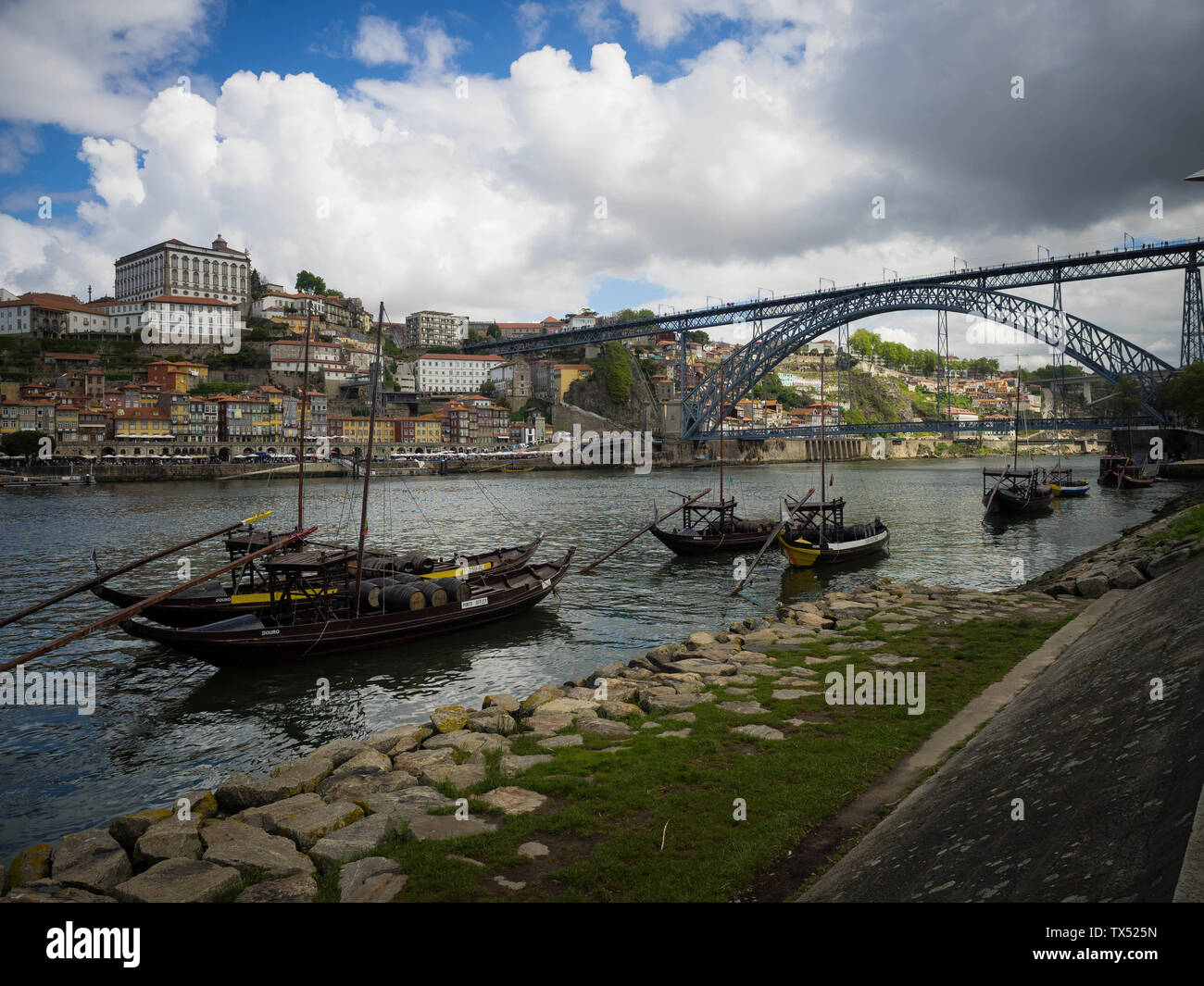 Casks of port aging in boats on the river Douro in Porto, Portugal with the World Heritage skyline behind them Stock Photo