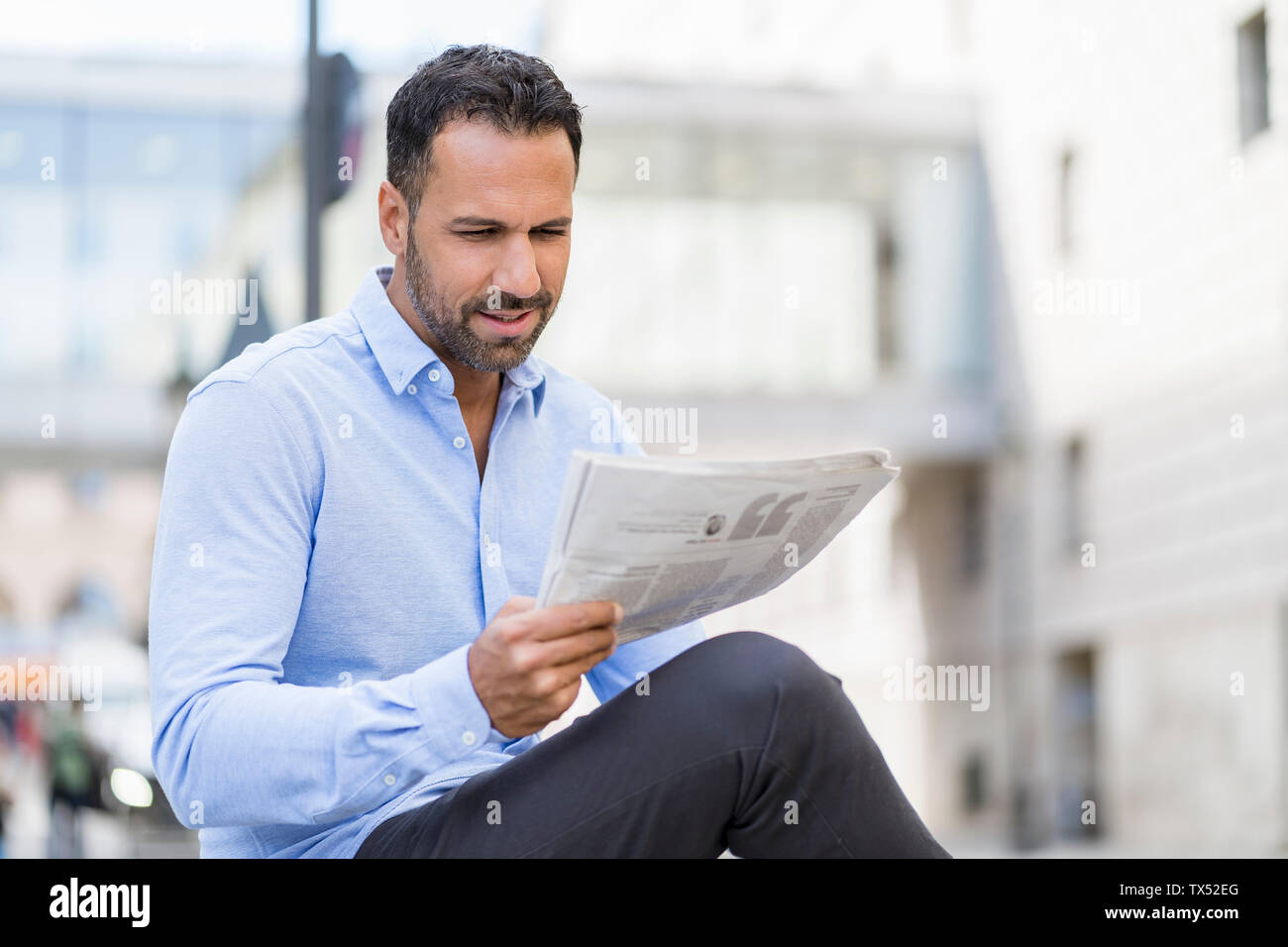 Businessman reading newspaper in the city Stock Photo