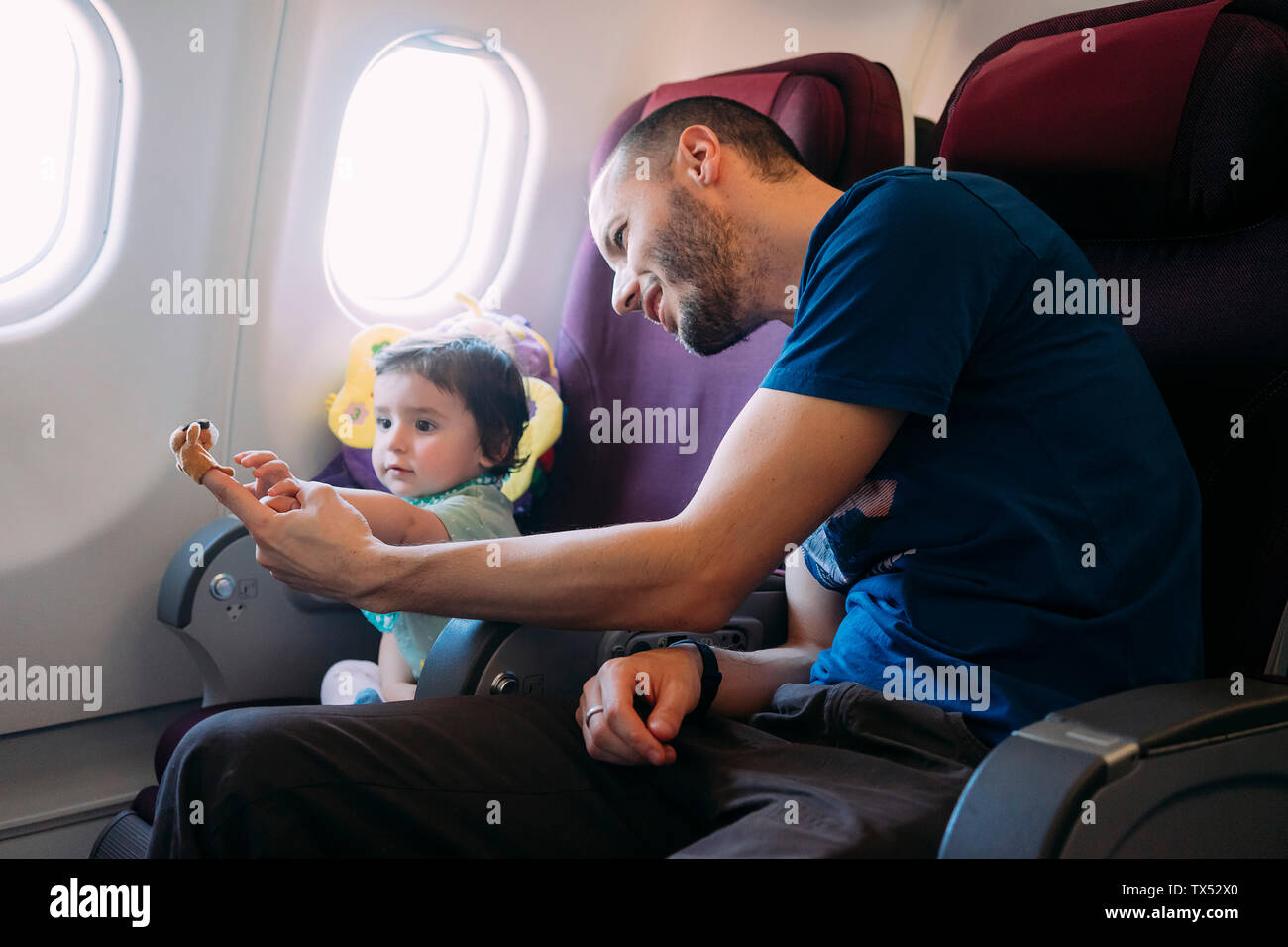 Father playing with his little daughter on airplane Stock Photo