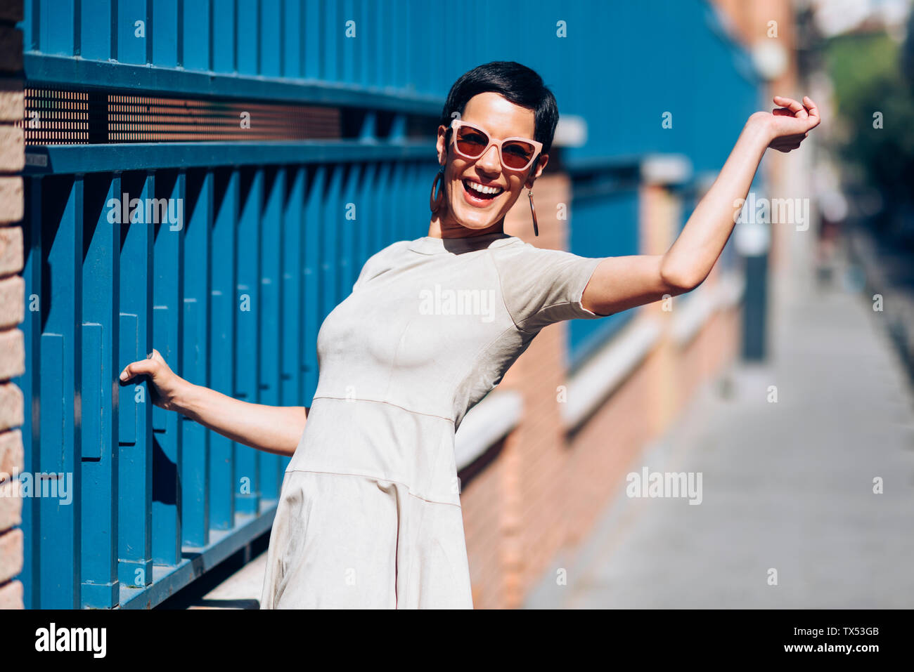 Happy fashionable young woman wearing dress and sunglasses Stock Photo ...