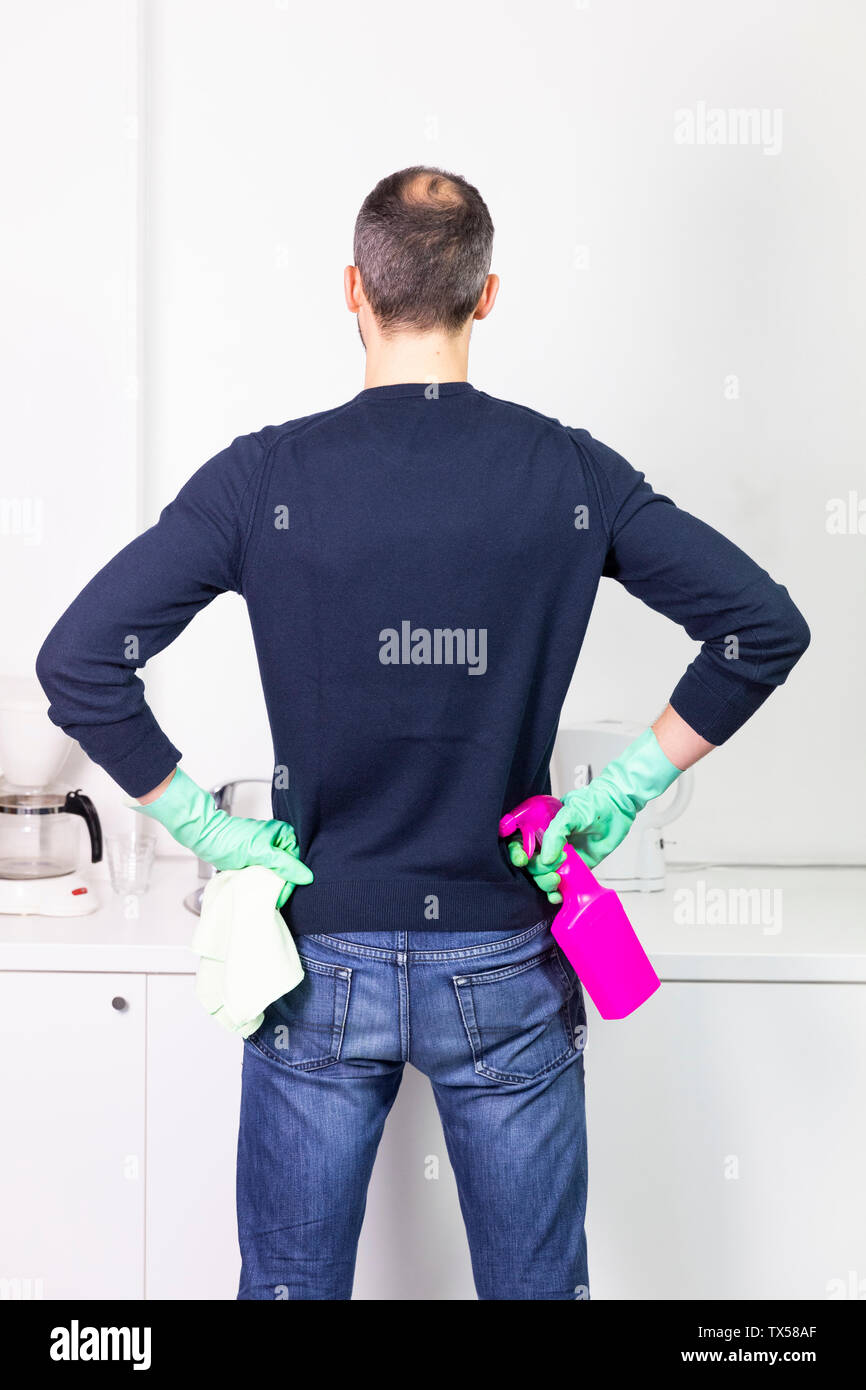 A man using cleaning products to clean. Stock Photo