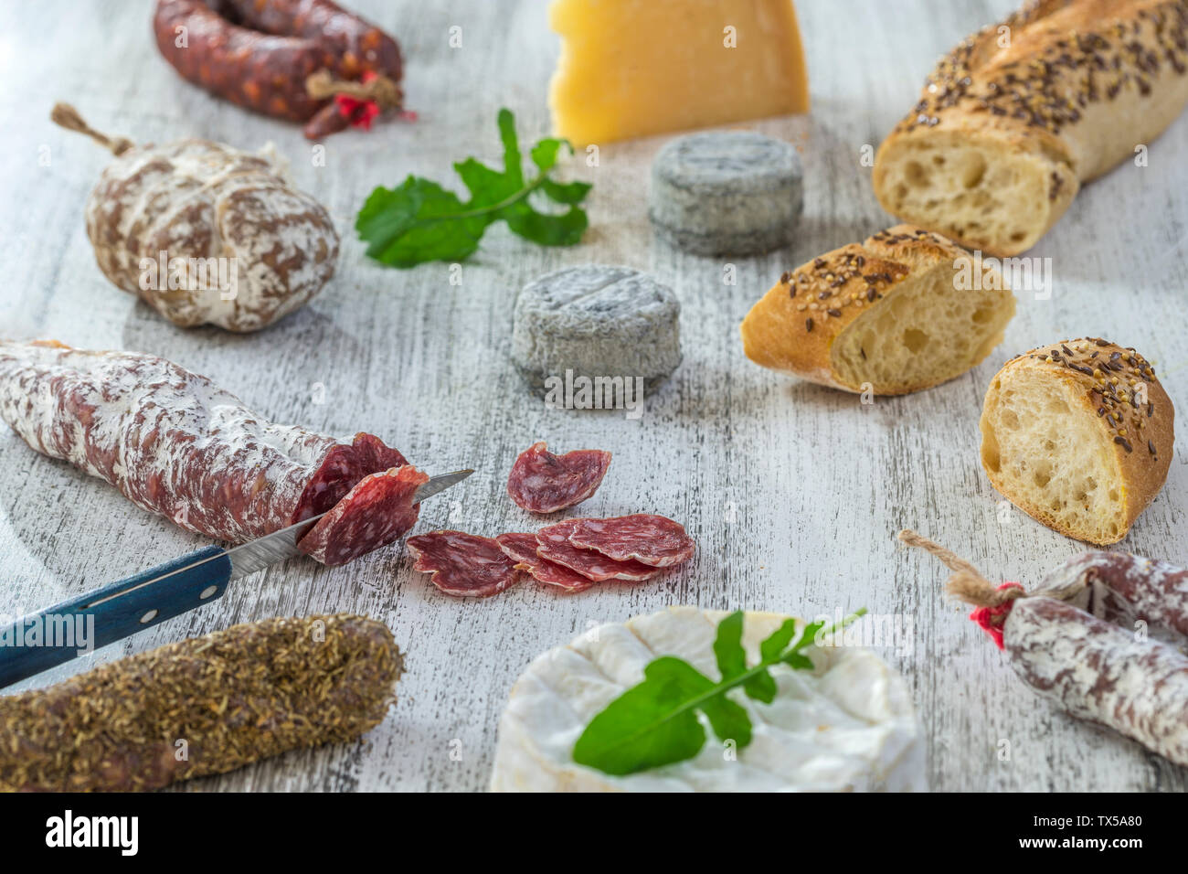 French snacks with wine - various types of cheeses, bread , dry saussages, charcuterie, red vine on a gray background. Top view. Food background Stock Photo