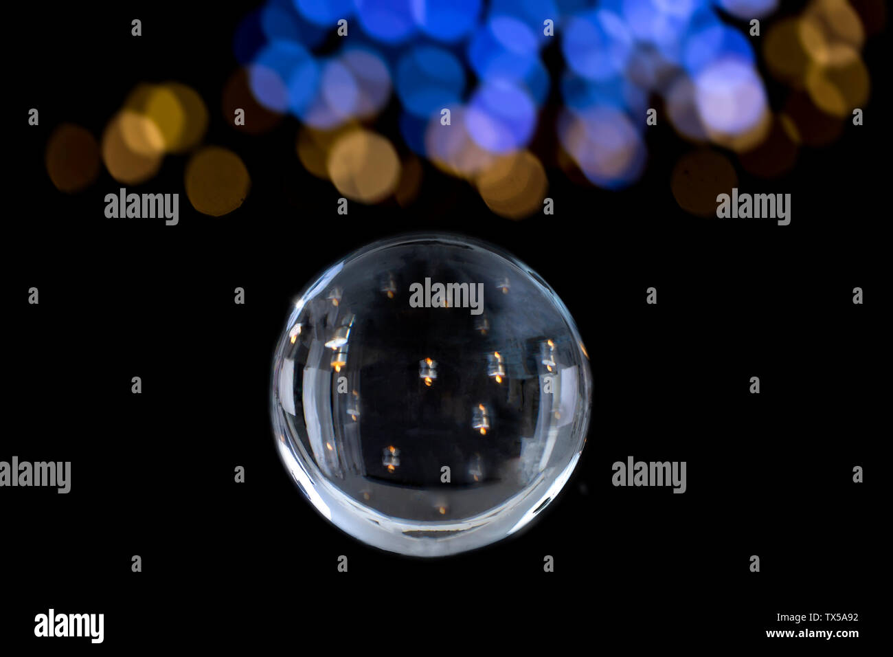 Candle lighted in Magic crystal ball of divination. Interpretation of dreams, Psychic, fortune telling ion black with blury blue gold lights Stock Photo