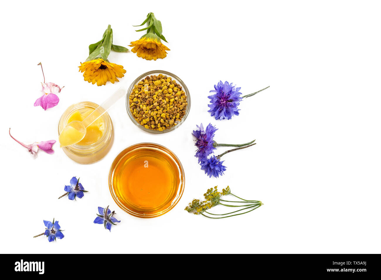 Variety of raw organic honey bee products board surrounded by flowers on white background Stock Photo