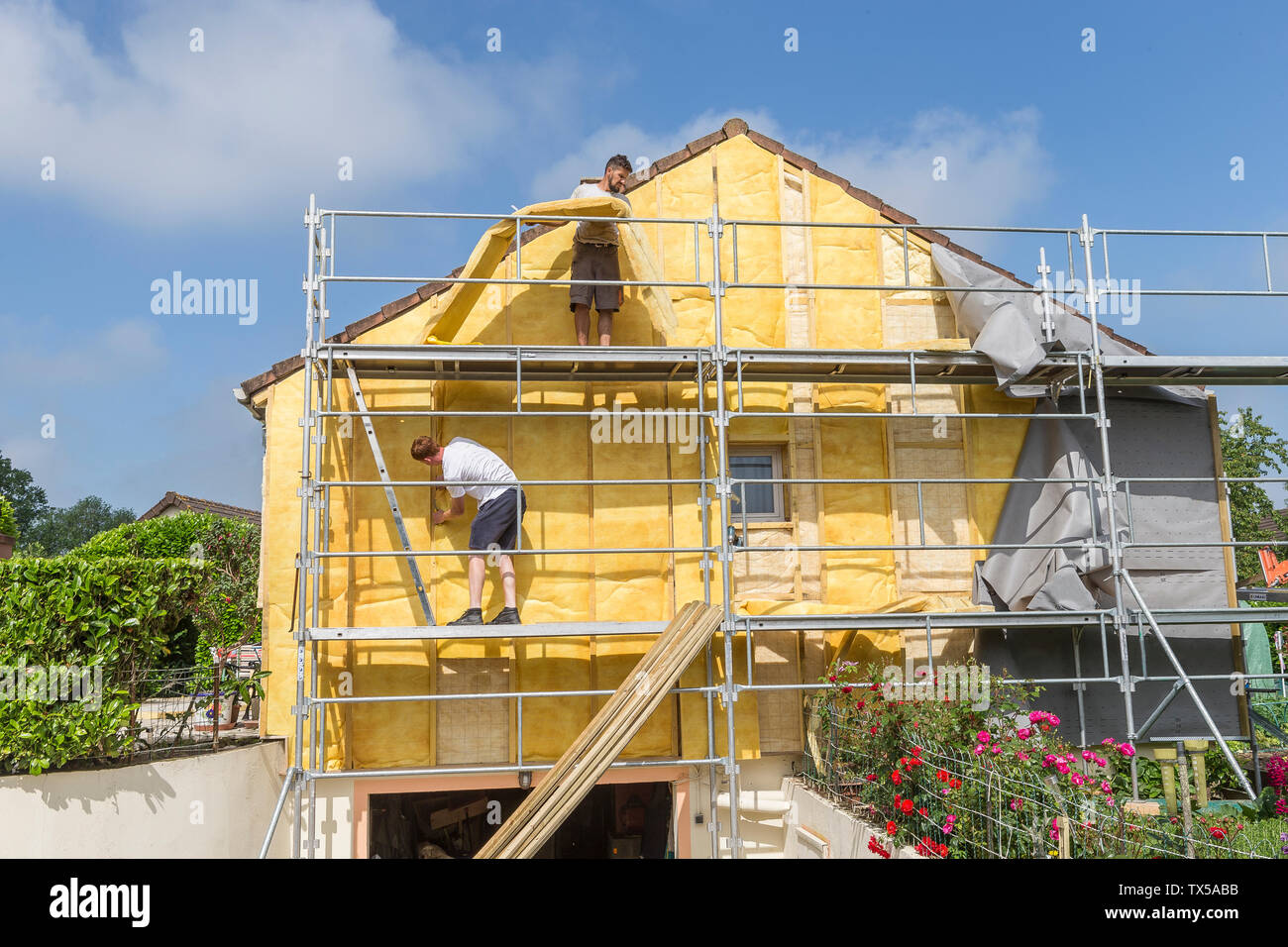 House insulation. scaffolding,mineral wool, composite panels cladding of buildings, resource conservation, Stock Photo