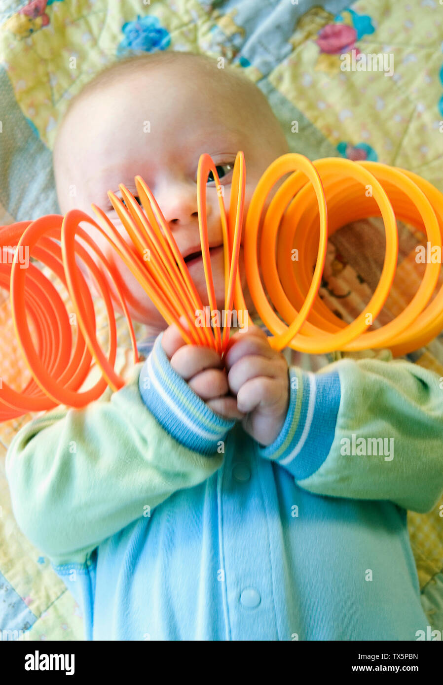 A 6 month old child with Down Syndrome playing with a therapy toy Stock