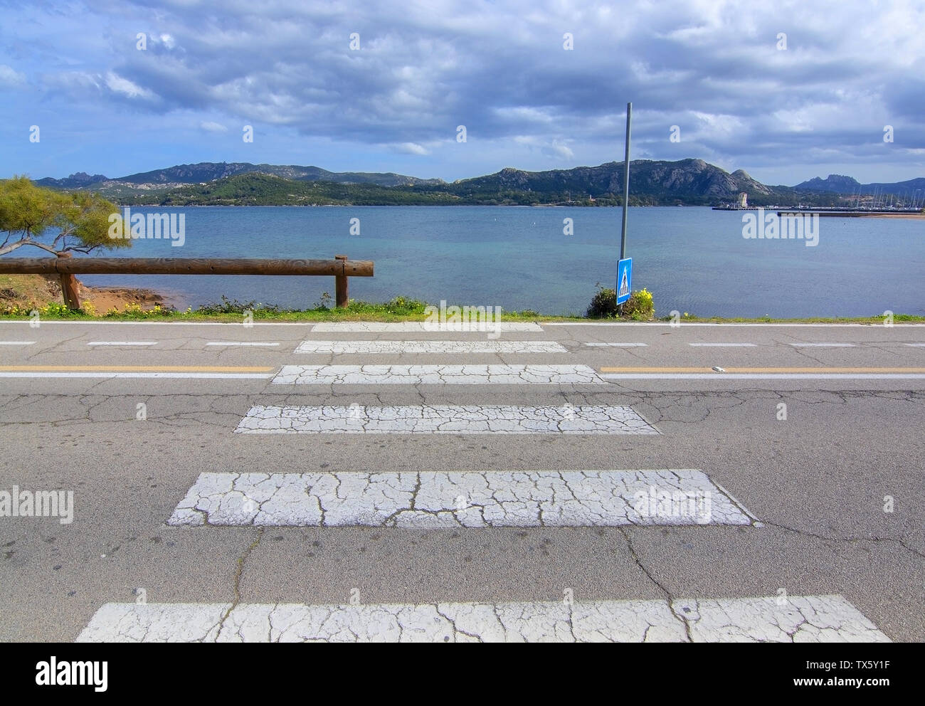 Pedestrian crossing zebra walk leading into water abstract image in Sardinia, Italy Stock Photo