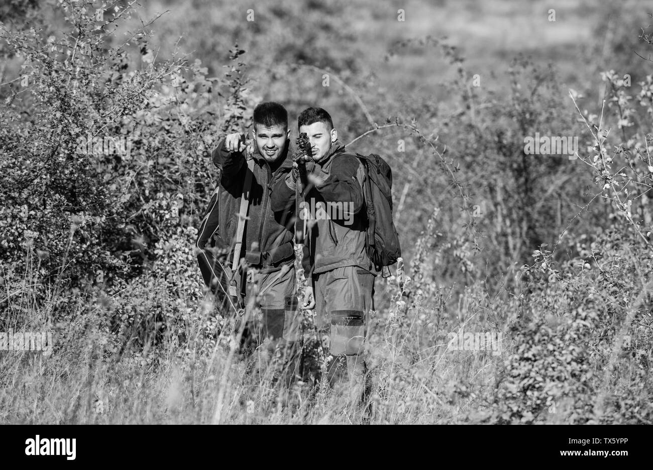 Friendship of men hunters. Man hunters with rifle gun. Boot camp. Military uniform fashion. Army forces. Camouflage. Hunting skills and weapon equipment. How turn hunting into hobby. best friends. Stock Photo
