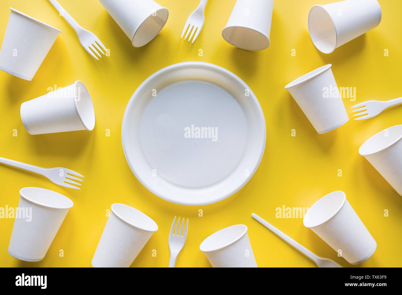 Disposable picnic utensils for recycling on yellow. Environment eco