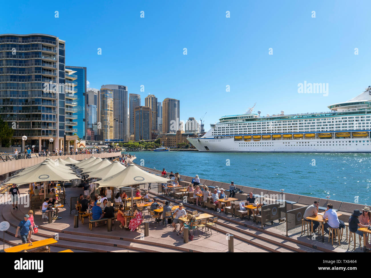Cruise ship docked at Circular Quay with the skyline of Sydney Central Business District behind and the Opera Bar in the foreground, Sydney, Australia Stock Photo