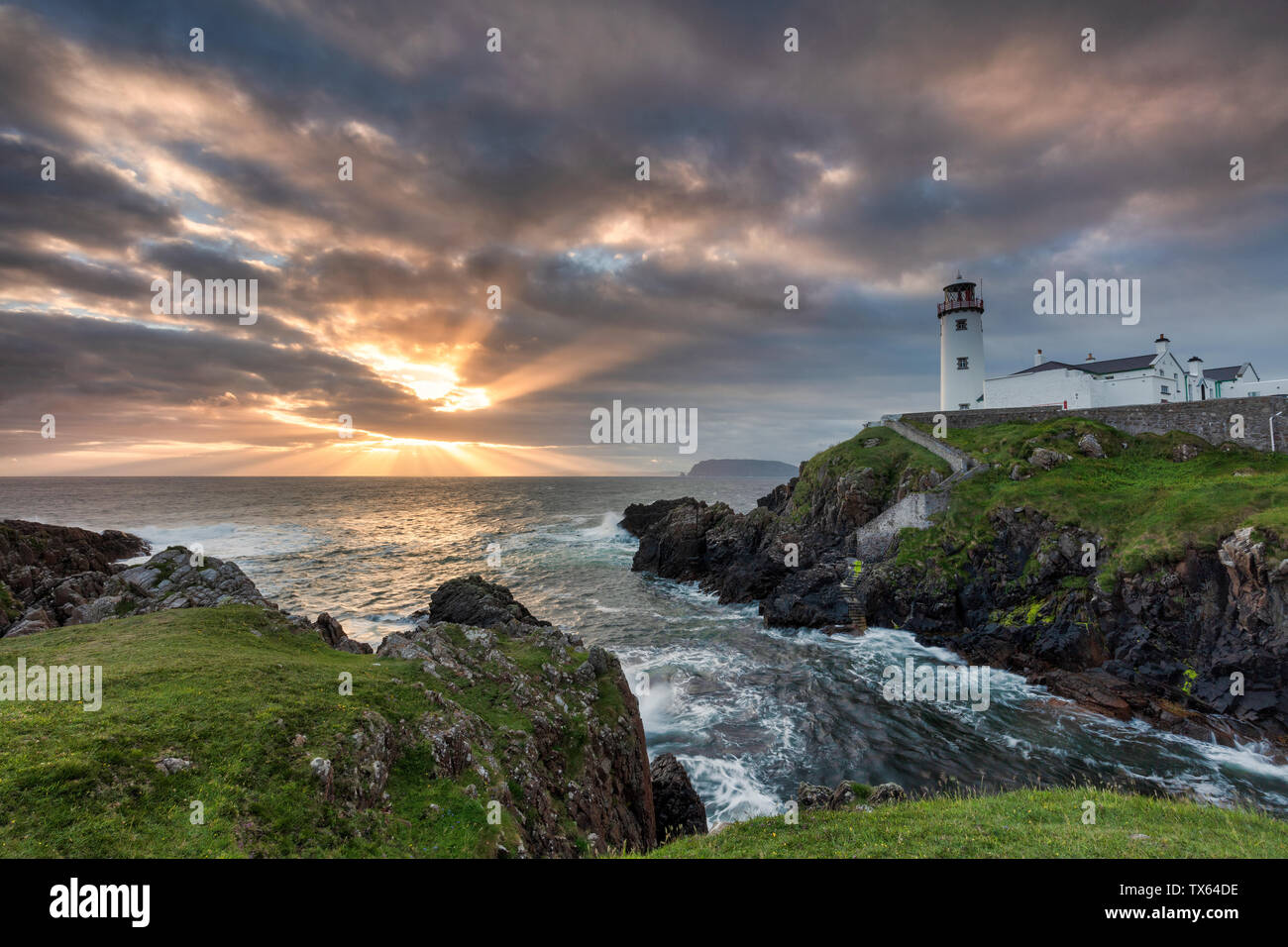 Sunrise over the Atlantic Ocean and Fanad Head Lighthouse in County Donegal Ireland Stock Photo