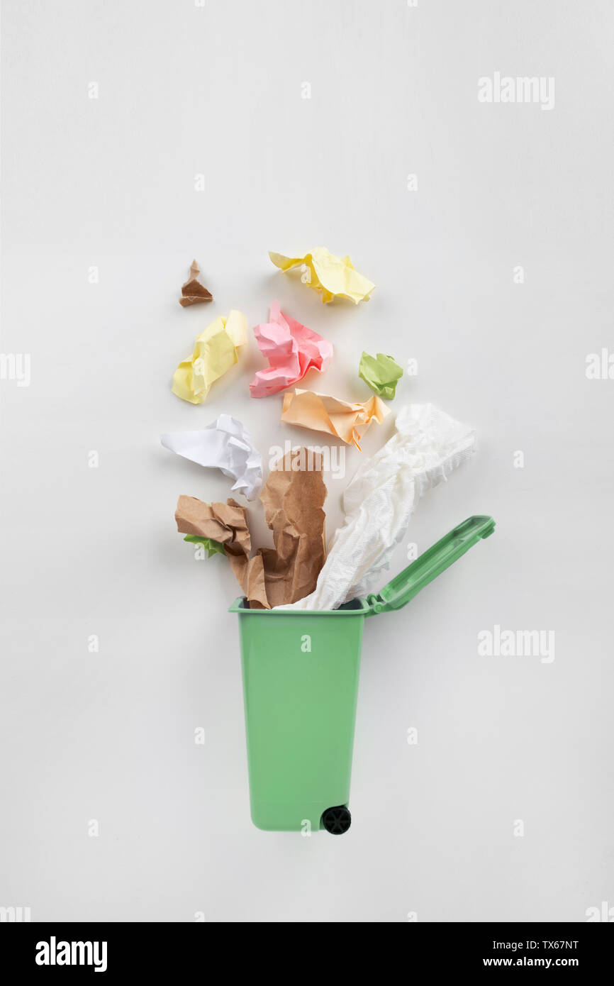 Trash bin with paper waste on a gray background. Recycling concept Stock Photo
