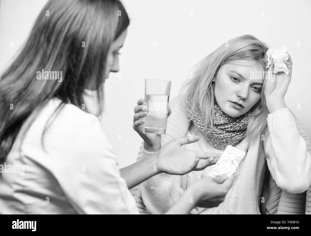 Woman consult with doctor. Girl in scarf hold tissue while doctor offer treatment. Cold and flu remedies. Tips how to get rid of cold. Recognize symptoms of cold. Remedies should help beat cold fast. Stock Photo