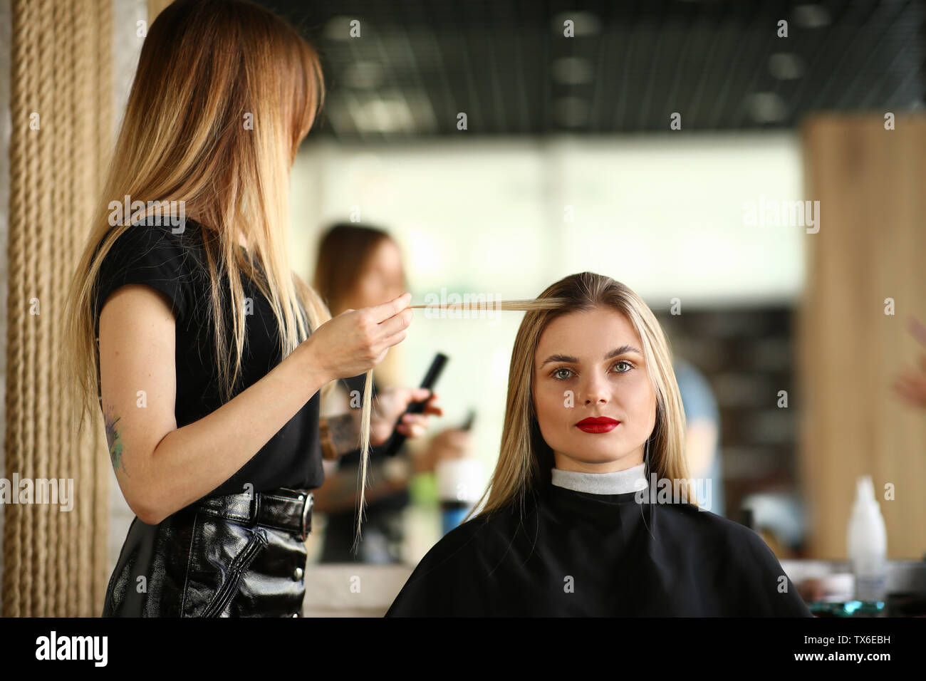 Hairdresser Holding Long Hair Strand Of Client Beautiful Blonde