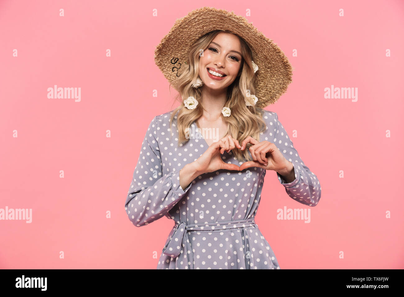 Portrait of a beautiful young blonde woman wearing summer straw hat ...