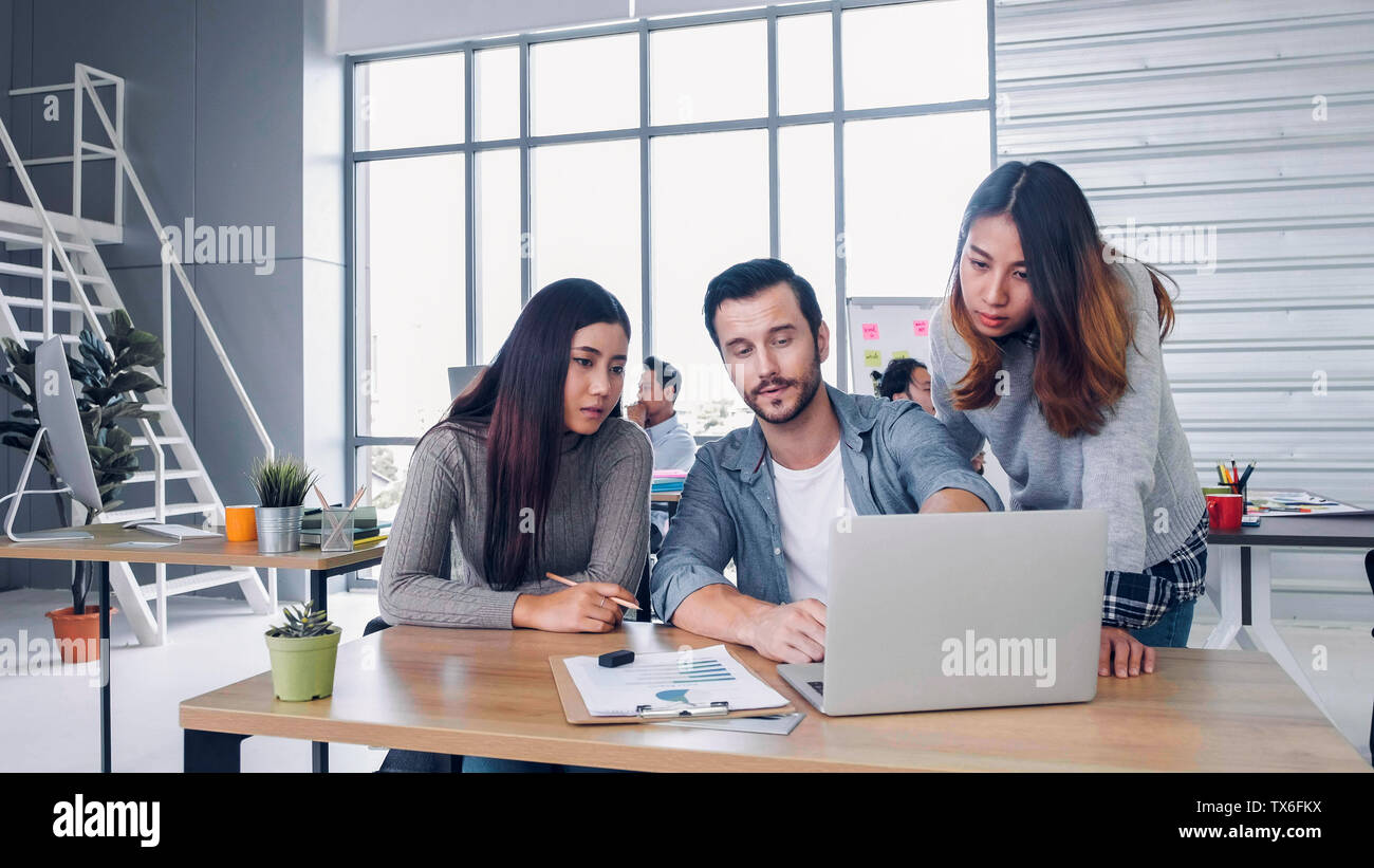 Group of creative designer casual meeting with laptop at modern office in morning at desk.casual workplace lifestyle. Stock Photo