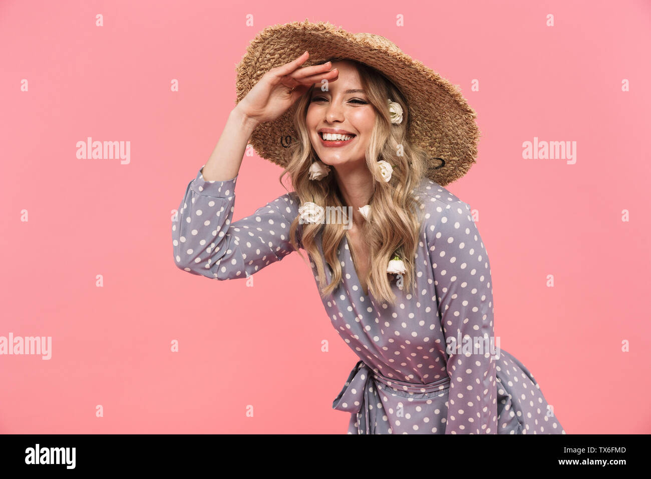 Portrait of a beautiful young blonde woman wearing summer straw hat ...
