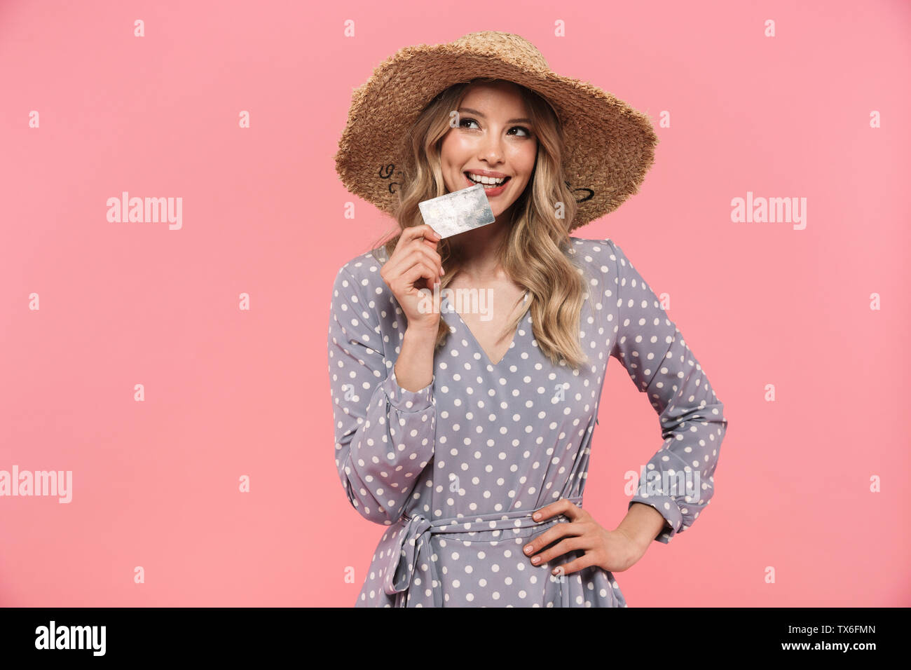 Portrait of a beautiful young blonde woman wearing summer straw hat ...