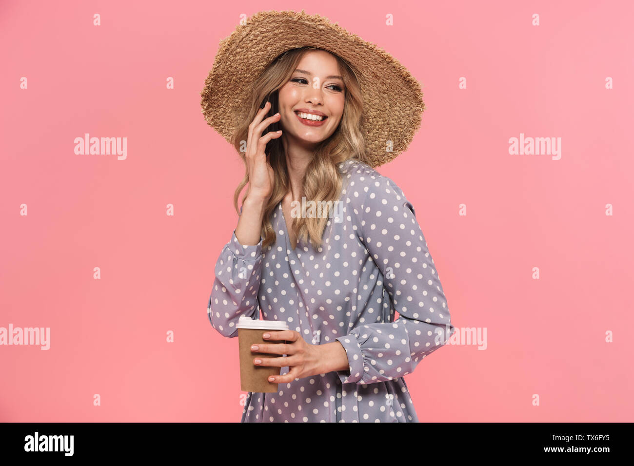 Portrait of a beautiful young blonde woman wearing summer straw hat ...