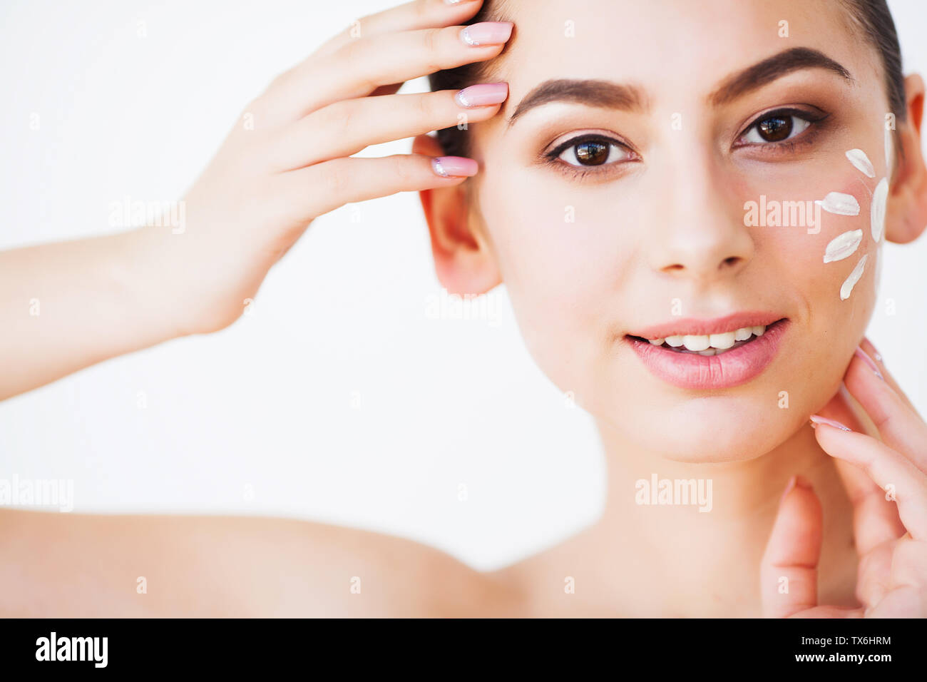 Sun Tanning. Beauty Girl Applying Sun Tan Cream on her Face Stock Photo