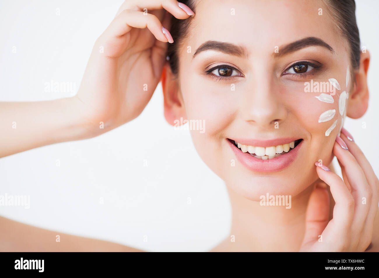Sun Tanning. Beauty Girl Applying Sun Tan Cream on her Face Stock Photo
