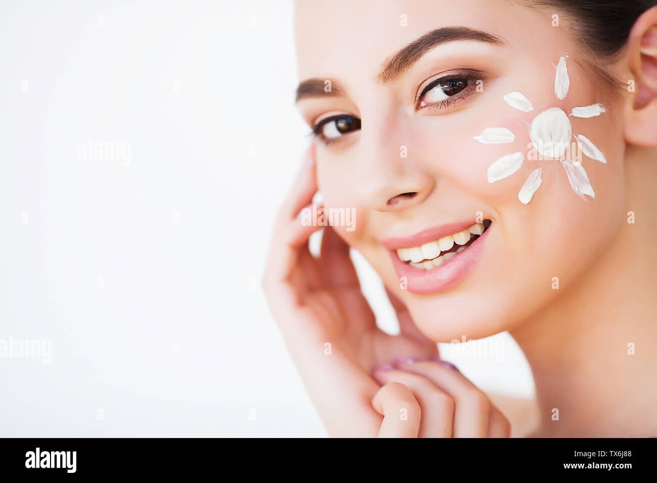 Sun Tanning. Beauty Girl Applying Sun Tan Cream on her Face Stock Photo