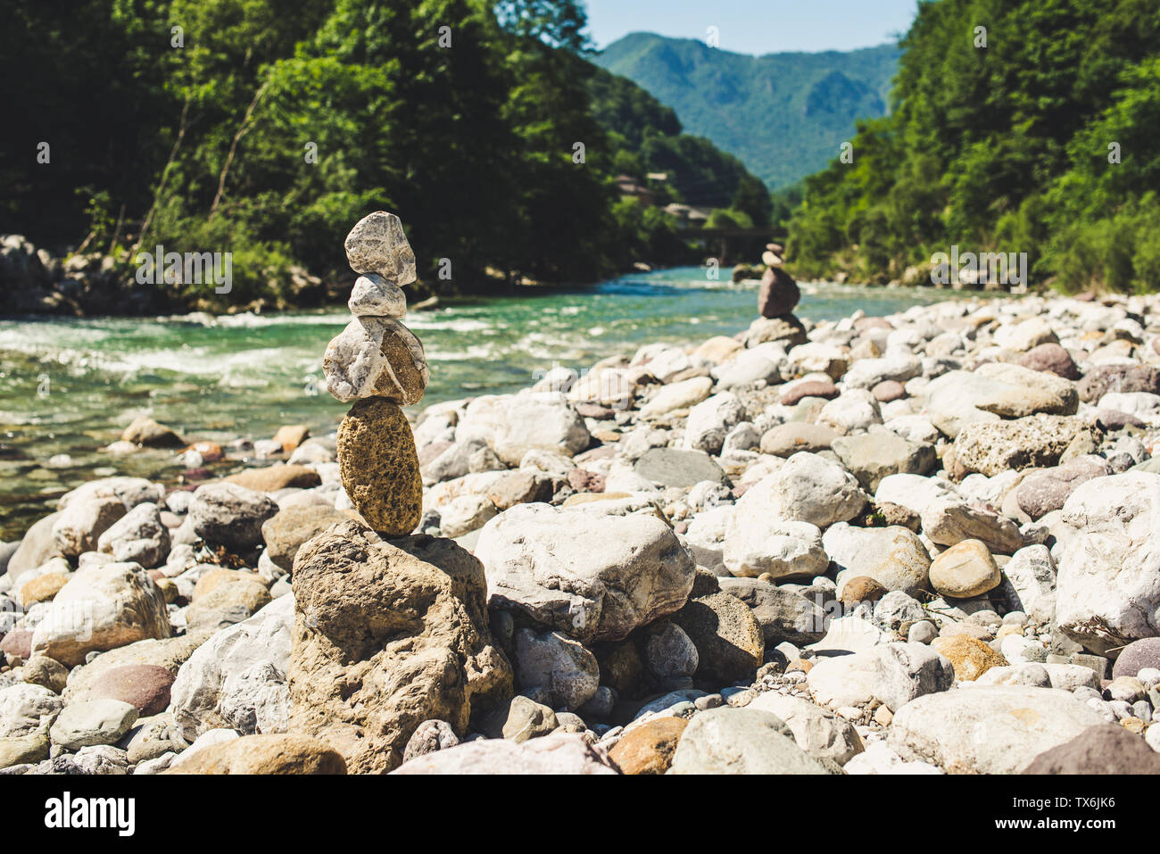 zen stones in equilibrium pyramid at a pebble river beach - concept of equilibrium with nature Stock Photo