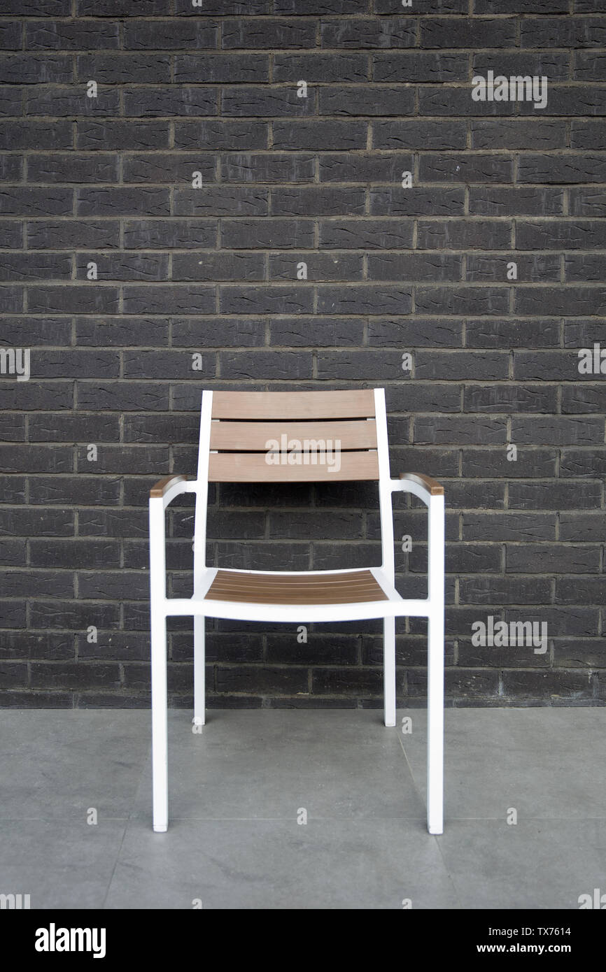 Empty chair against the dark brick wall Stock Photo