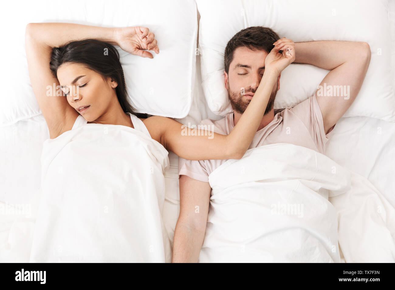 Image of a happy loving couple sleeping in bed under blanket Stock