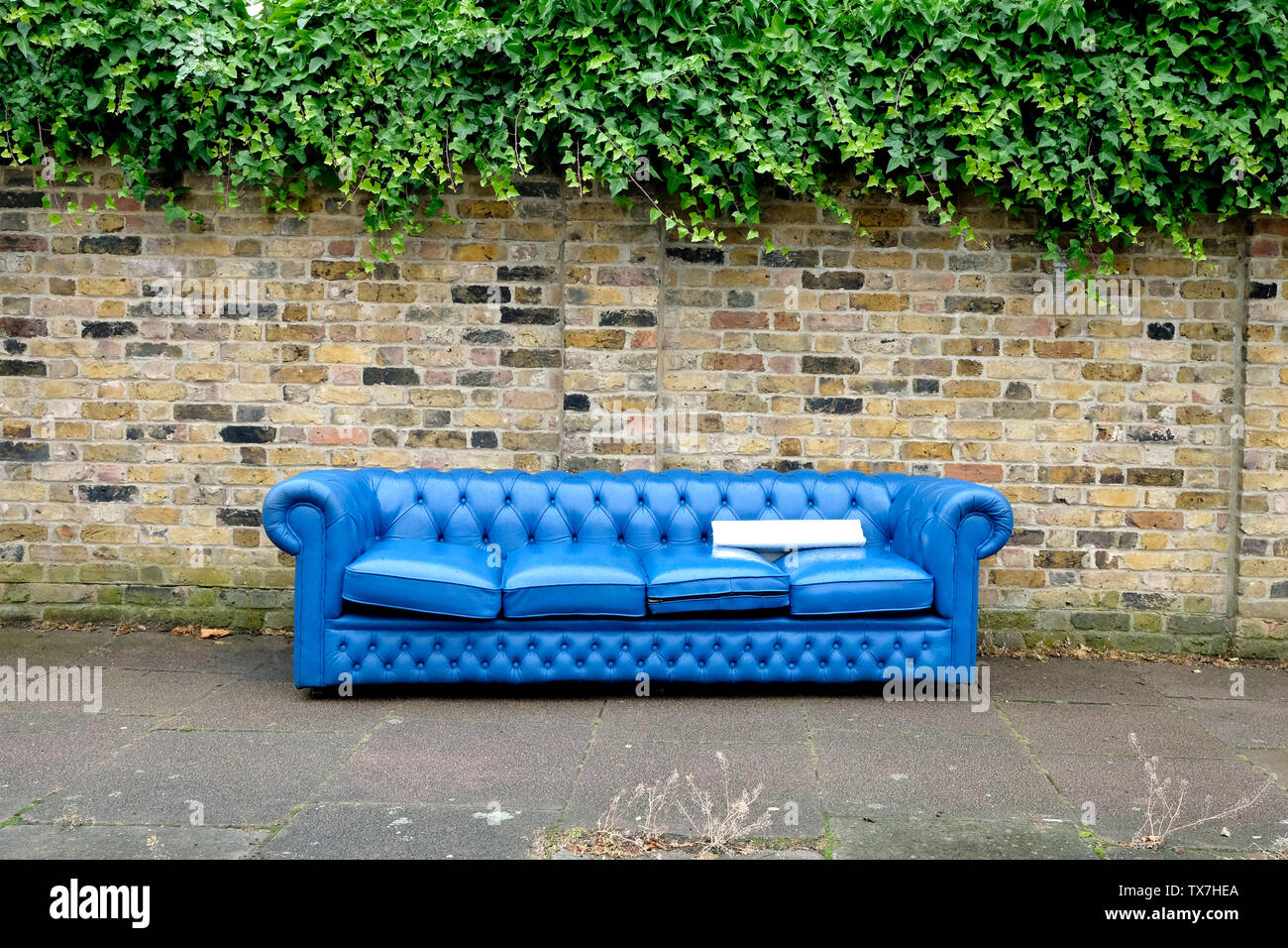 A Blue Abandoned Sofa On A Pavement North London Uk Stock A Blue Abandoned Sofa On A Pavement North London Uk Stock