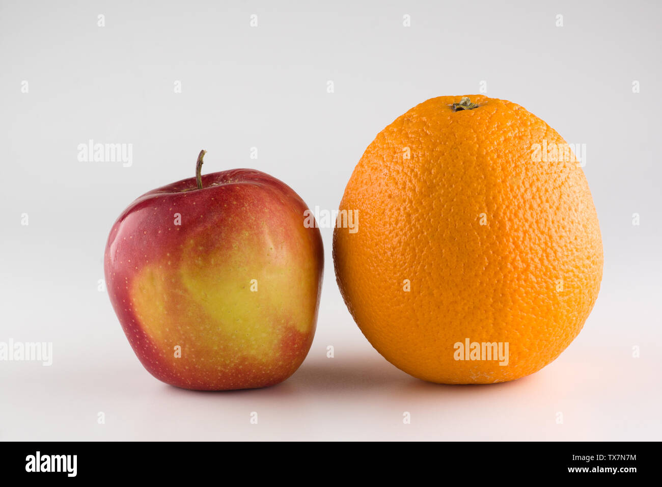 ripe beautiful apple with orange in the juice isolated on white